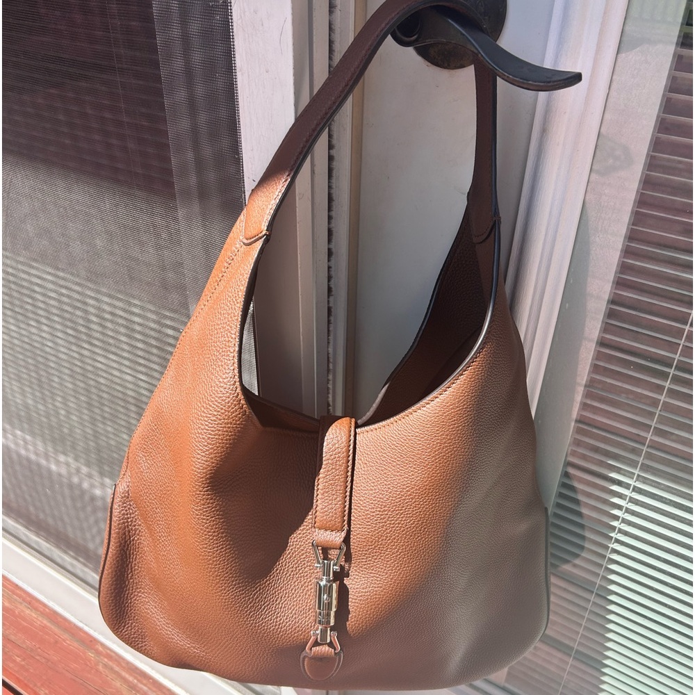 The  Gucci Jackie is brown cowhide Leather with Light gold-toned Hook closure
